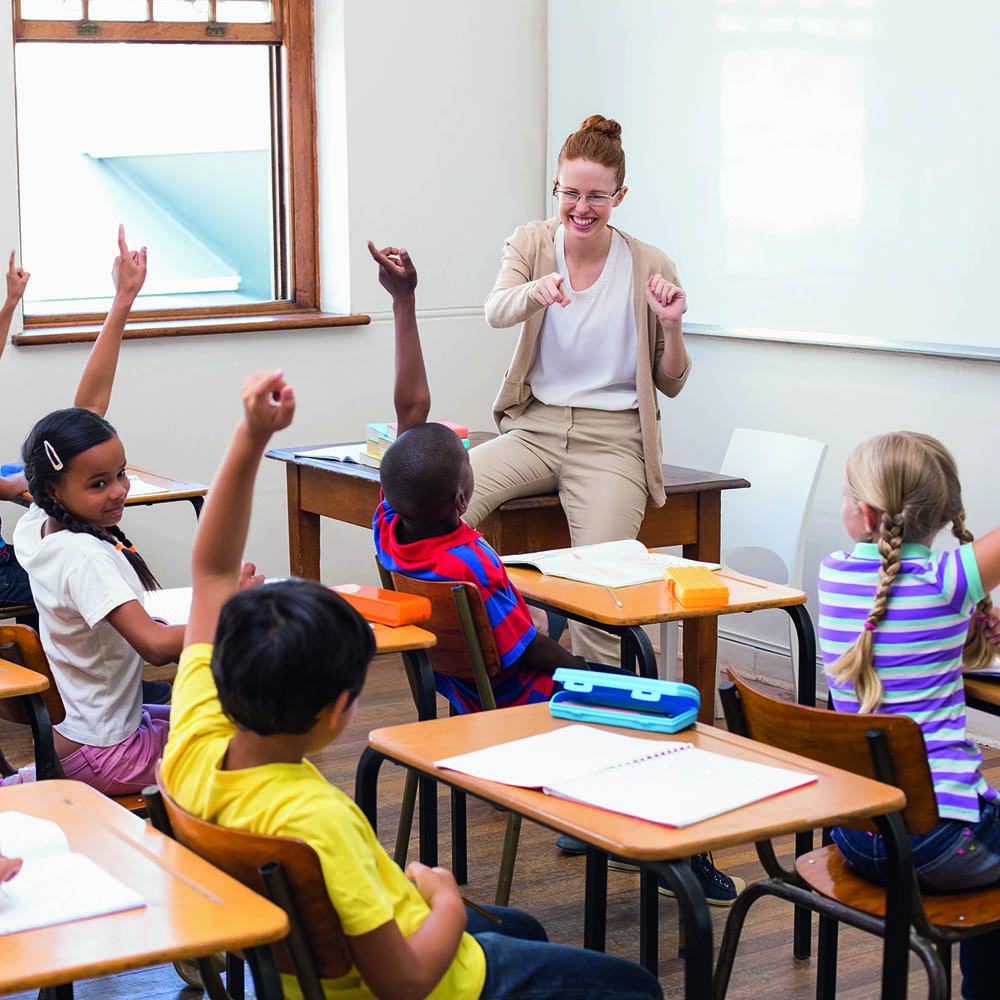 Lehrerin mit Schülern, die aufzeigen / Credit: wavebreakmedia/shutterstock.com